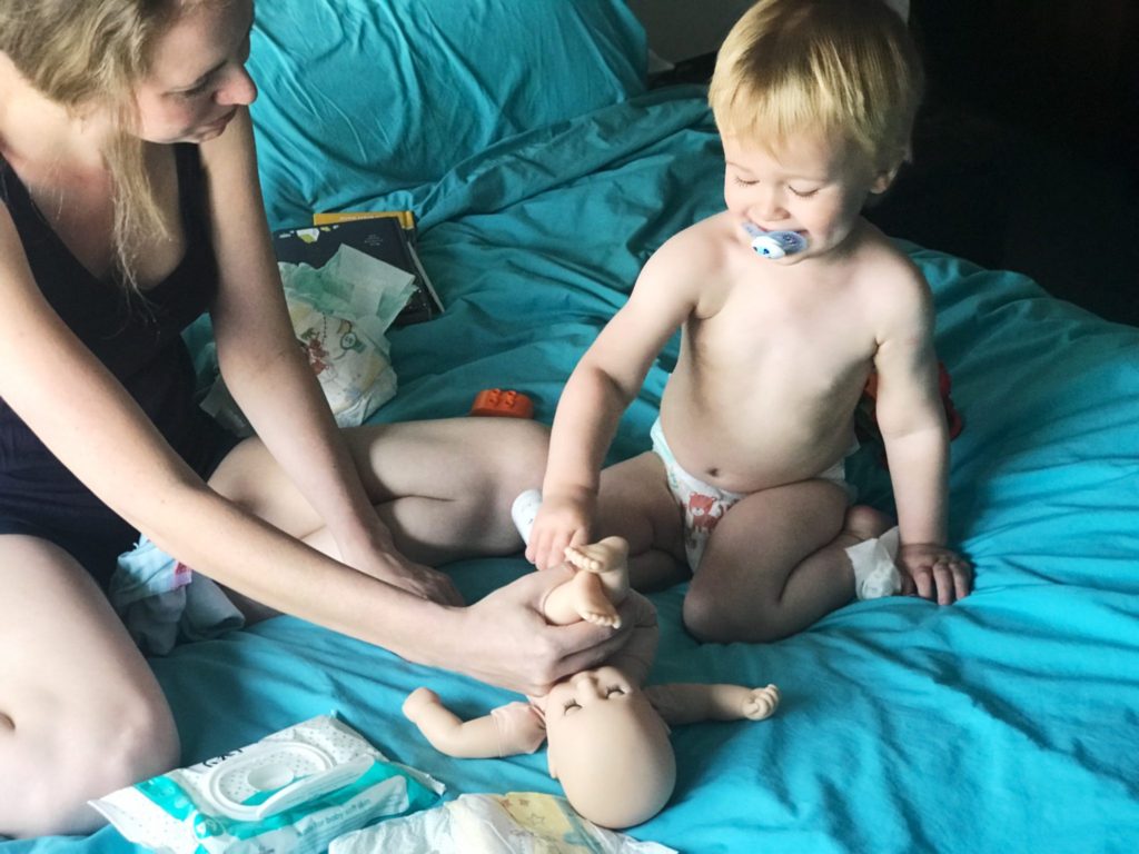 Dexter helping Mummy to change Baby Annabell Brother's nappy on the bed using nappy cream