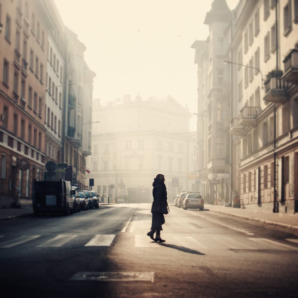 Woman stood on a zebra crossing on a foggy street