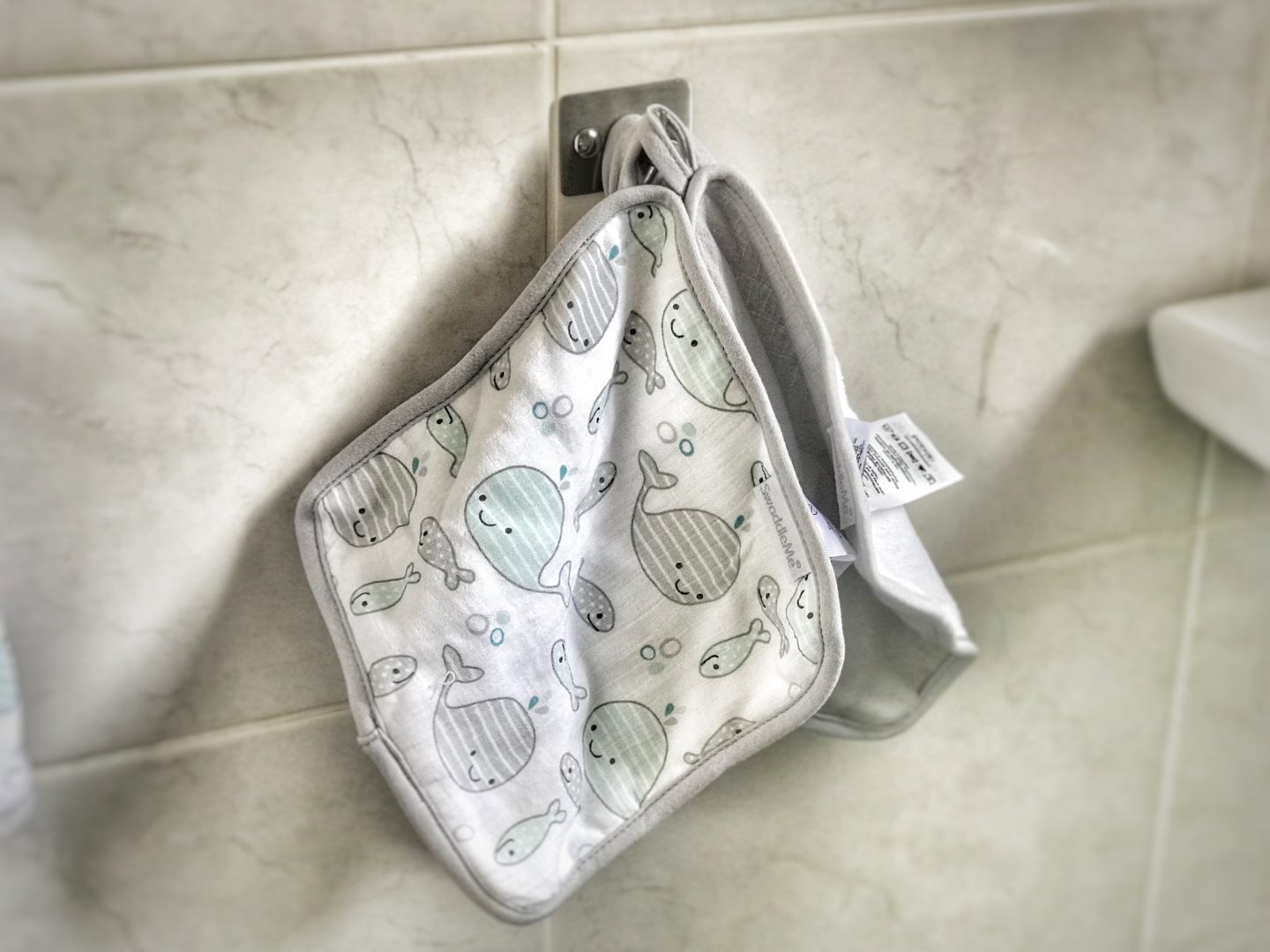 two swaddleme bath to bed gift set terry cloths hanging from a hook in a bathroom