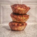 three broccoli and courgette muffins stacked neatly on top of each other