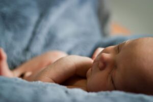 a newborn baby lying in a blue towel