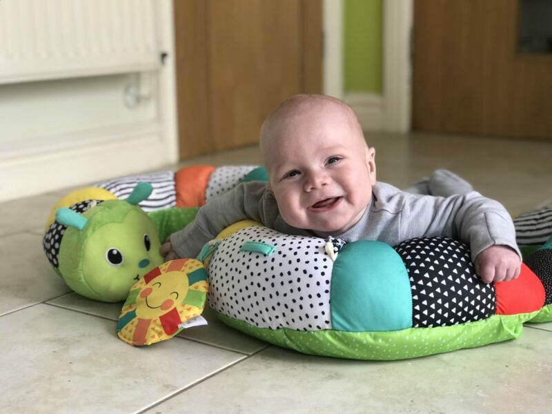 Felix using the Infantino Prop-a-Pillar tummy time support in the kitchen smiling happily