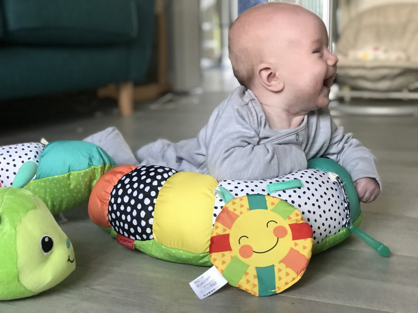 Felix using his Infantino Prop-a-Pillar tummy time support in the lounge, propping himself up and laughing