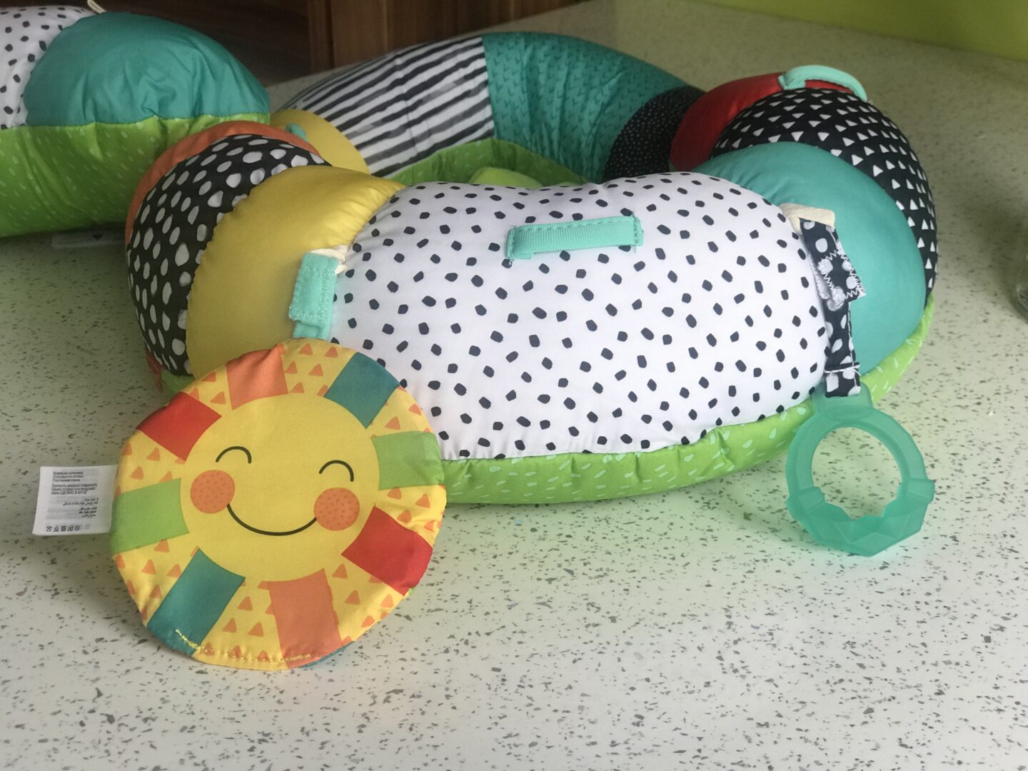 A close up of the Infantino Prop-a-Pillar tummy time support showing the crikly sun and BPA-free teether