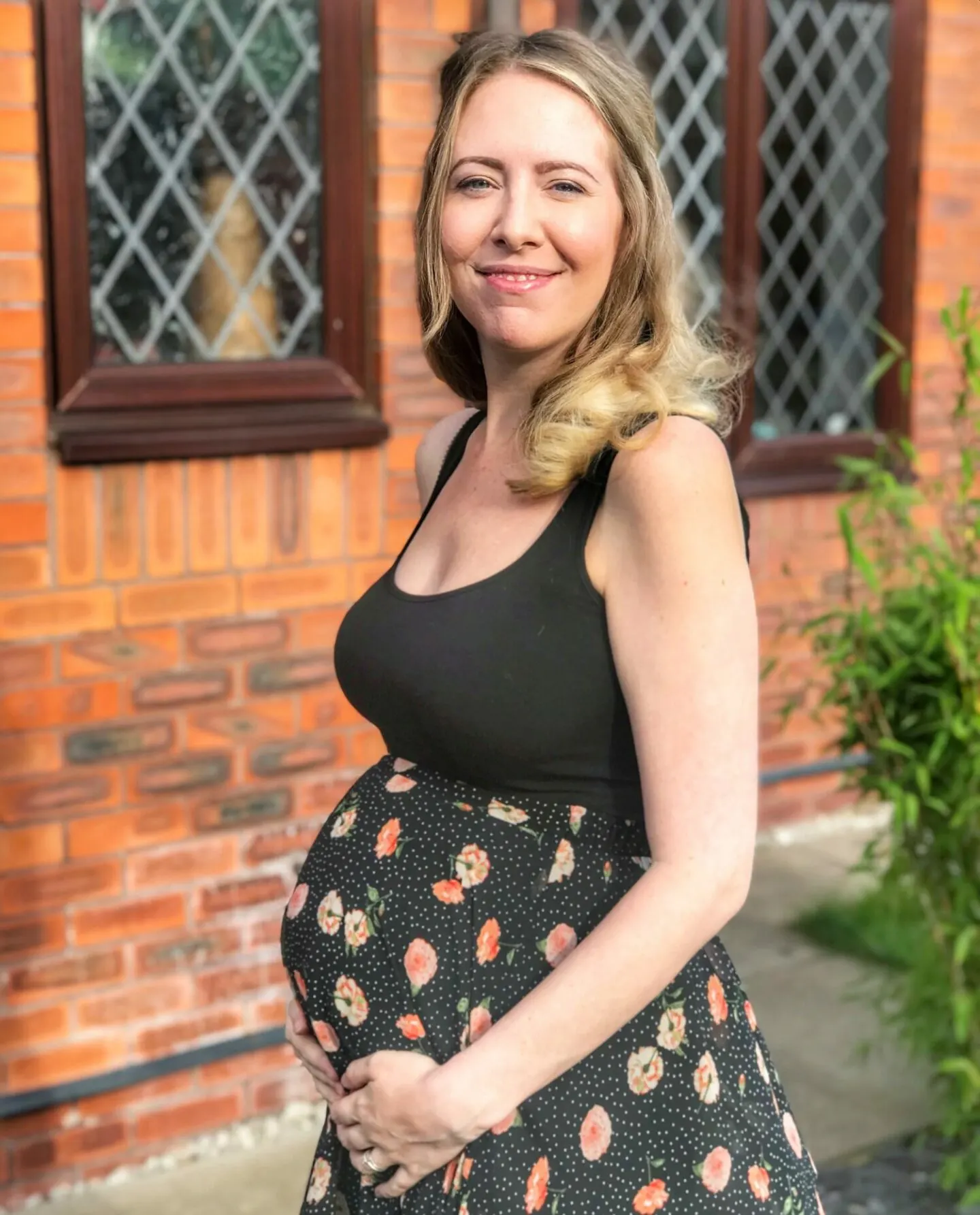Mummy to Dex, baby led weaning mummy blogger aka Nicola stood in front of her home wearing a black vest top and skirt, six months pregnant