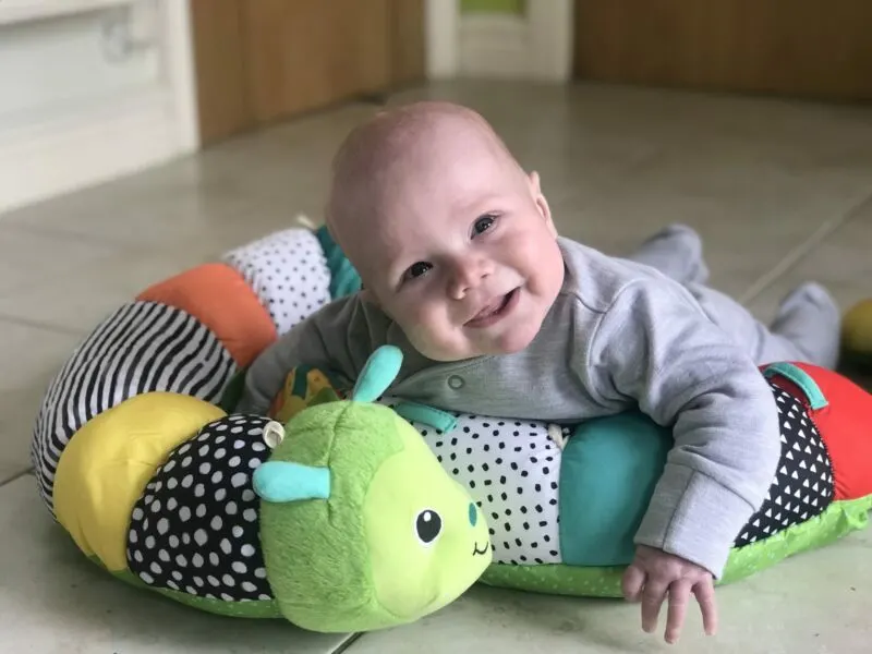 Felix using the Infantino Prop-a-Pillar tummy time support in the kitchen smiling happily
