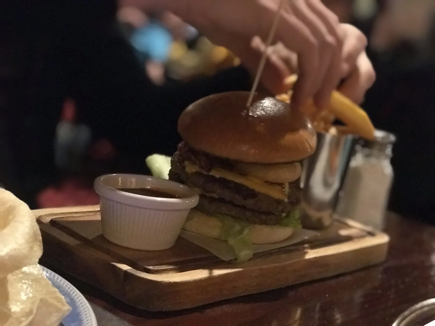 main meal of burger, sauce and fries served on a thick cut wooden board in the buccaneer, blackpool