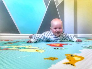Felix doing tummy time on the Skip Hop Reversible playmat With a big smile on his face