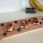 eggy bread for babies surrounded by blueberries on a chopping board