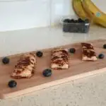 eggy bread for babies surrounded by blueberries on a chopping board