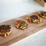 baby led weaning sweet potato and spinach burgers for babies on a wooden serving board