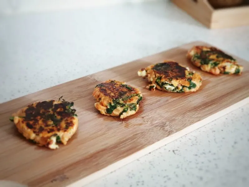 baby led weaning sweet potato and spinach burgers for babies on a wooden serving board