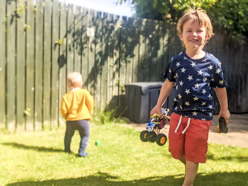 Decter in the garden holding his monster truck with Felix in the backgorund