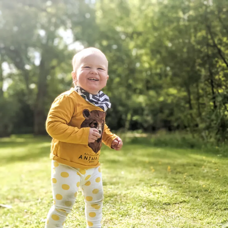 felix grinning at the camera in the woods