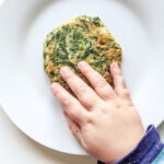 Felix touching the spinach fritters baby