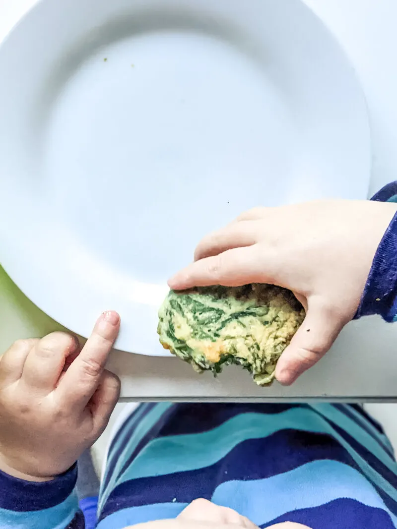 Felix eating spinach fritters baby