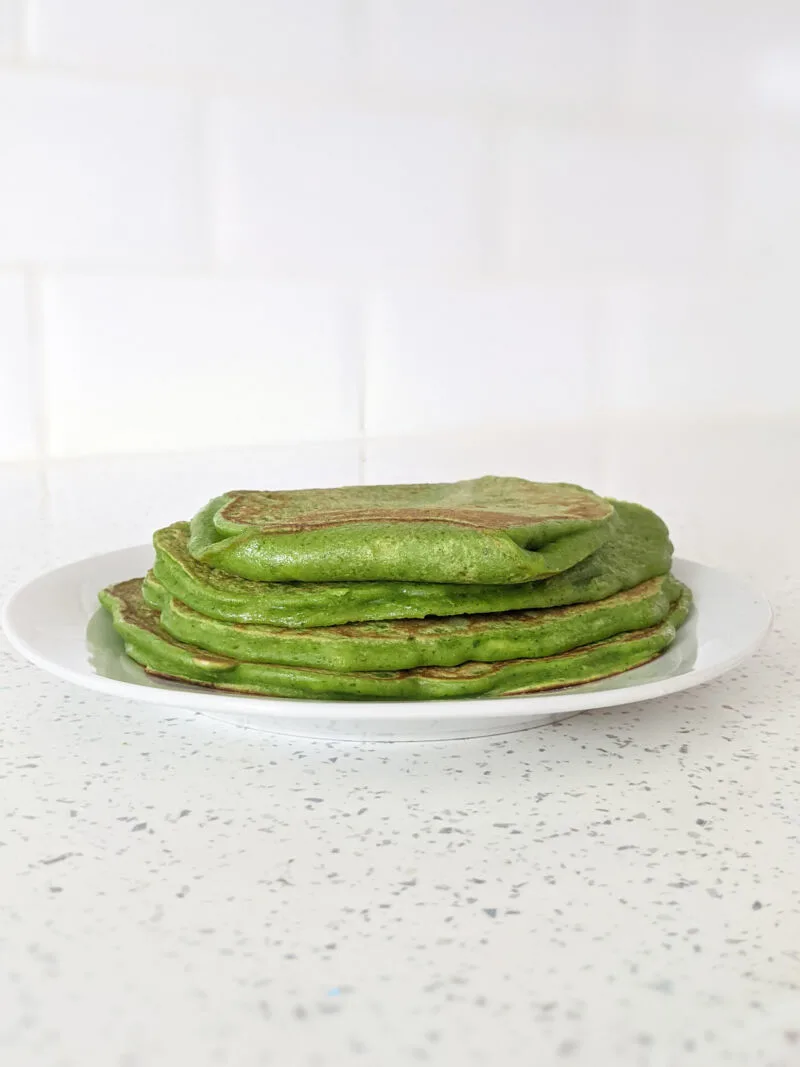 banana and spinach pancakes for baby stacked on a plate