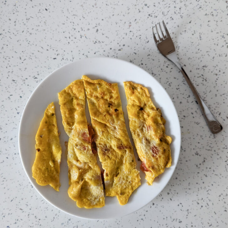 cheese and tomato omelette for baby with a fork