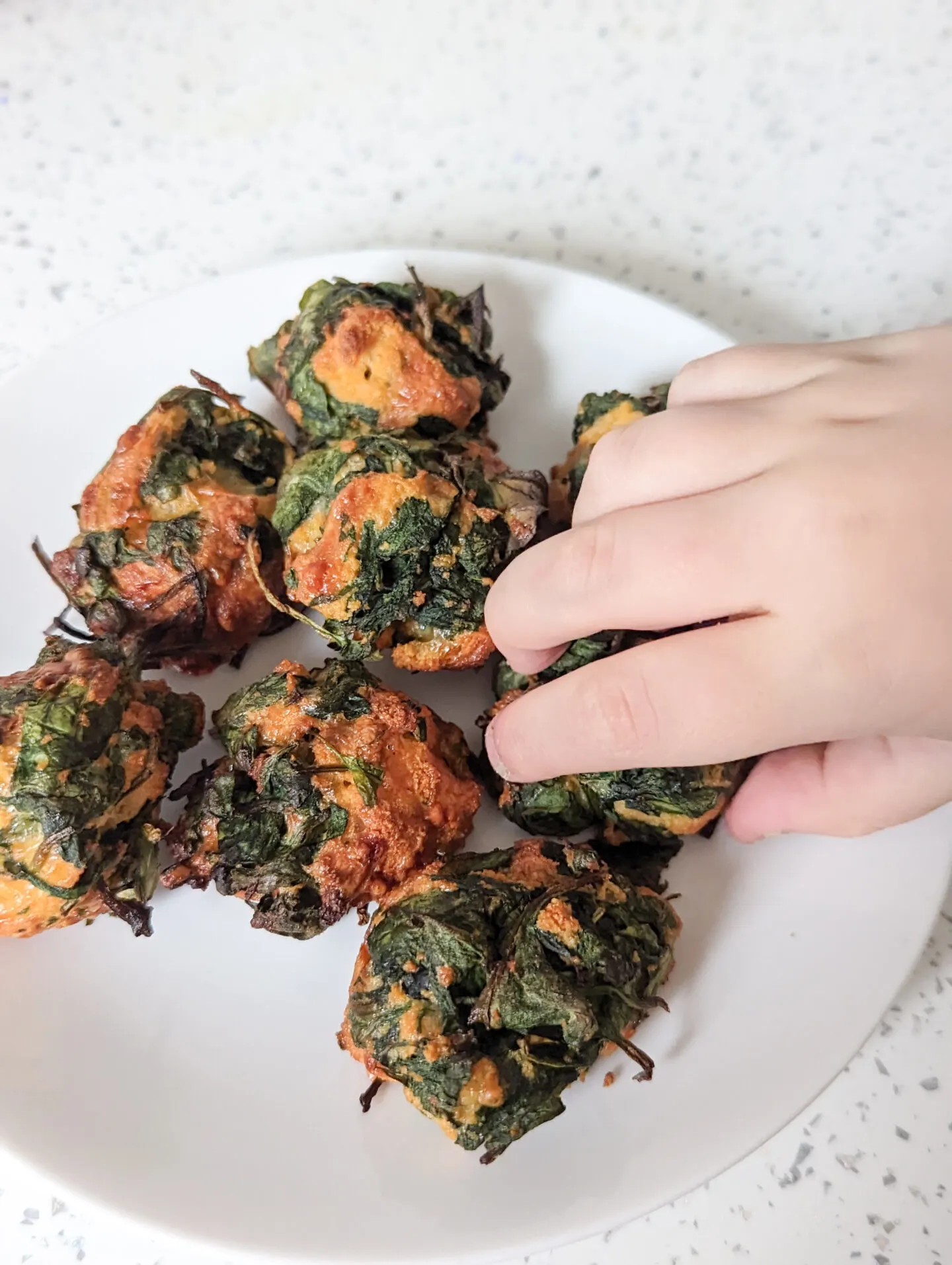 spinach bites for baby being grabbed